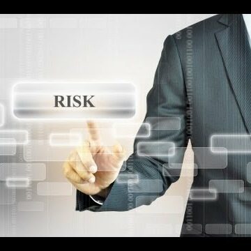 Ejecutivo de negocios interactuando con botón virtual RISK sobre fondo tecnológico de código binario y abstracción digital.