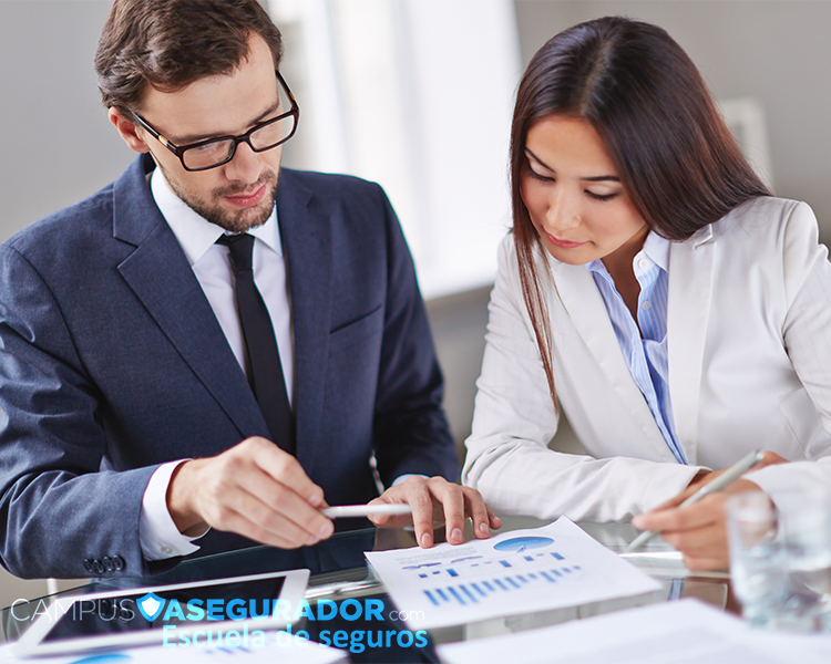 Dos profesionales analizando gráficos de datos en Campus Asegurador durante una sesión de formación técnica en seguros.
