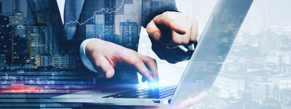 Profesional en traje utilizando laptop con superposición de gráfico bursátil y panorama urbano nocturno.