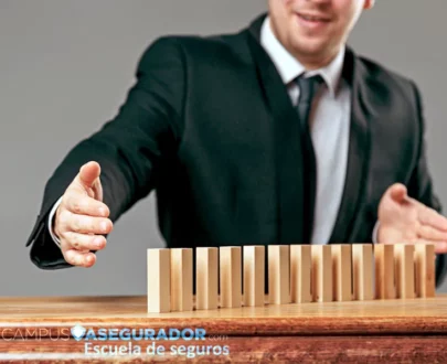 Profesional deteniendo una hilera de bloques de madera para evitar el efecto dominó. Marca Campus Asegurador visible.