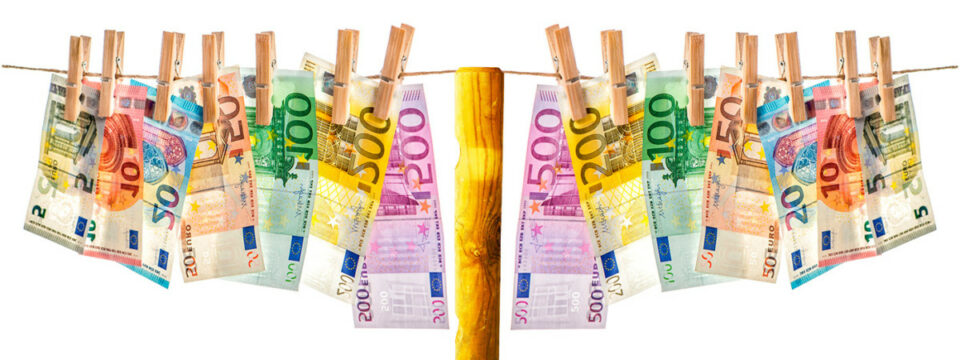 Billetes de euro de varias denominaciones sujetos con pinzas de madera en un tendedero sobre fondo blanco minimalista.