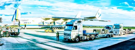 Avión Antonov An-225 Mriya cargando mercancía con camiones Zagrebtrans en pista aeroportuaria bajo cielo despejado.