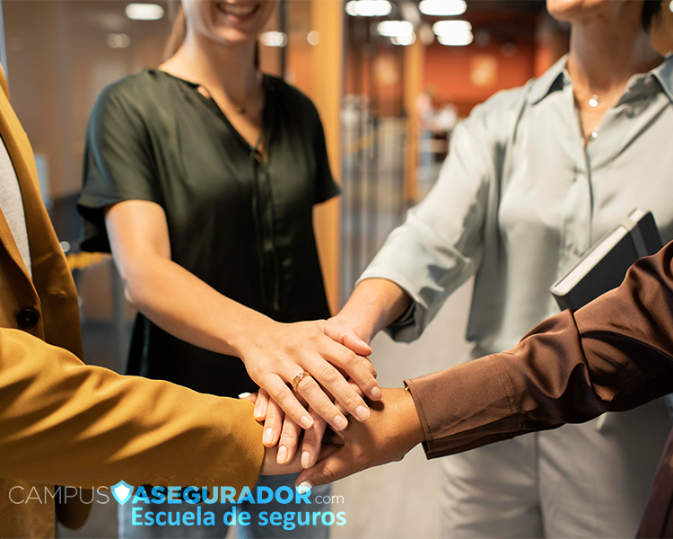 Profesionales del sector seguros uniendo manos sobre logo de Campus Asegurador, símbolo de trabajo en equipo y formación.