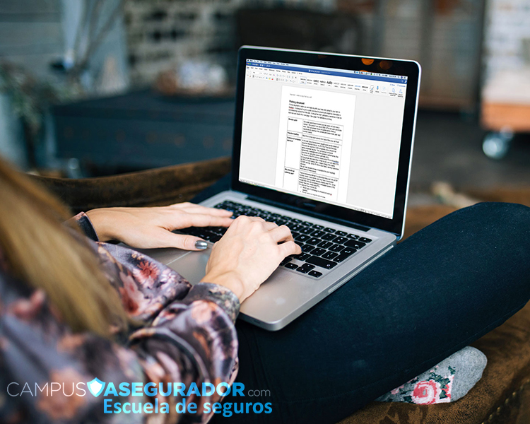 Persona trabajando en portátil con interfaz educativa de Campus Asegurador sobre entorno profesional de seguros.