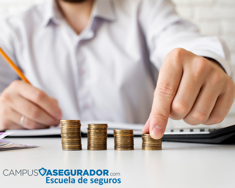 Contabilización de ahorros con pilas de monedas y logotipo Campus Asegurador Escuela de Seguros en entorno profesional.