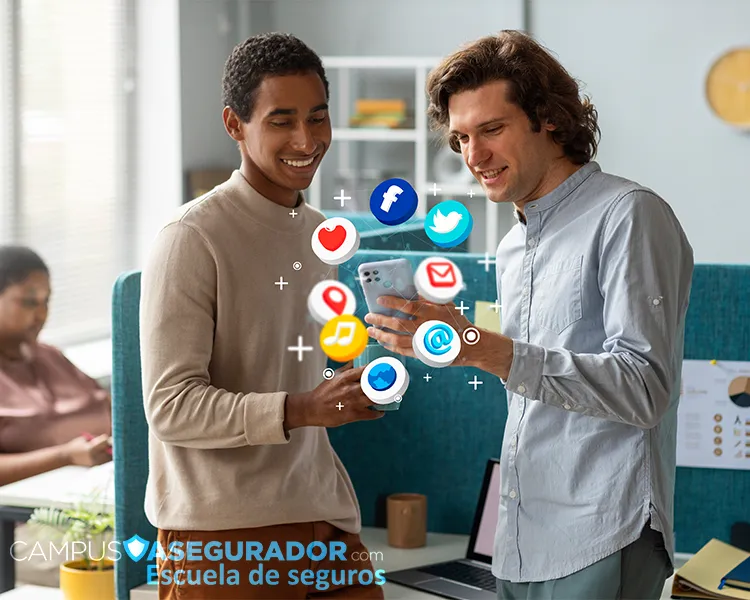 Dos profesionales analizan iconos digitales flotantes sobre smartphone en oficina de Campus Asegurador.