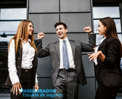 Tres profesionales celebrando éxito empresarial frente a Campus Asegurador, escuela técnica de formación en seguros.