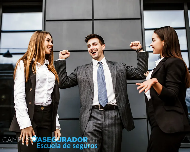 Tres profesionales celebrando éxito empresarial frente a Campus Asegurador, escuela técnica de formación en seguros.