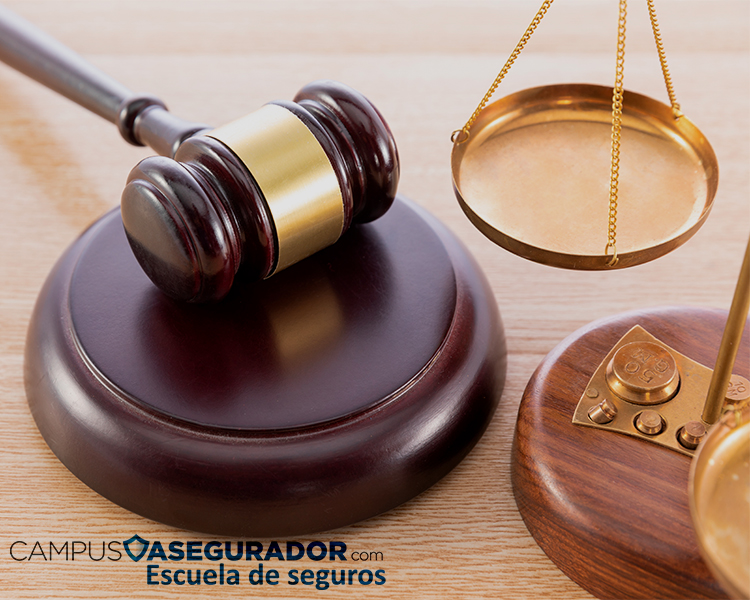 Mazo de madera y balanza de justicia dorada junto al logo de Campus Asegurador Escuela de Seguros en fondo de madera.