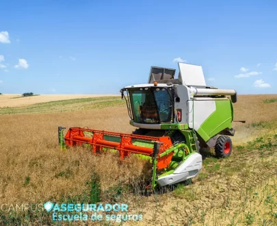Cosechadora agrícola operando en campo de cultivo seco bajo cielo azul para gestión de seguros de maquinaria pesada.