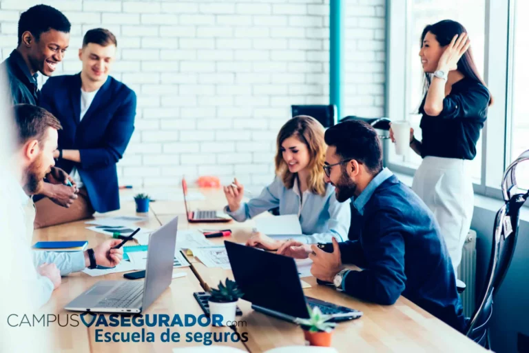Profesionales en formación de seguros colaborando en oficina moderna con portátiles para Campus Asegurador.