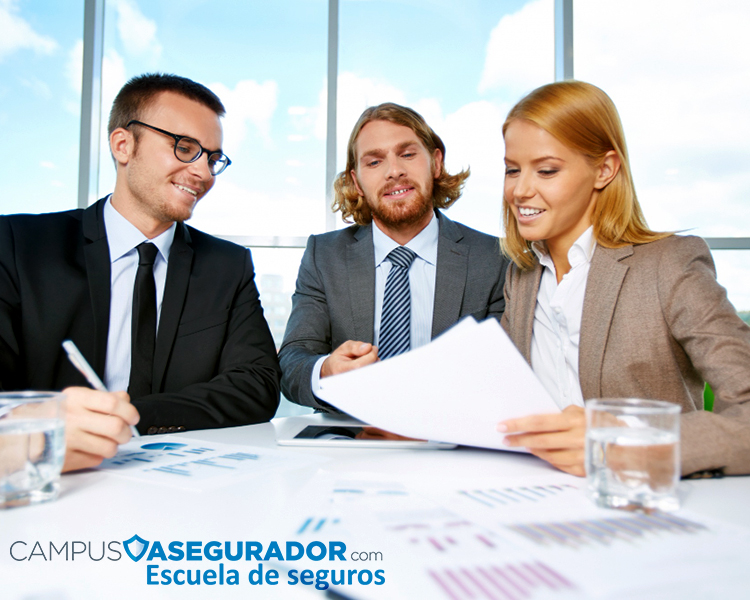 Tres profesionales analizando documentos en reunión colaborativa para formación en seguros de Campus Asegurador.