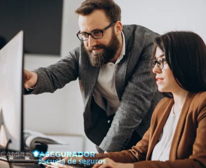 Profesionales analizando monitor en Campus Asegurador, escuela de formación especializada en el sector seguros.