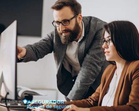 Profesionales analizando monitor en Campus Asegurador, escuela de formación especializada en el sector seguros.