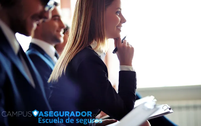 Profesional atendiendo seminario técnico en Campus Asegurador Escuela de Seguros durante sesión de capacitación corporativa.