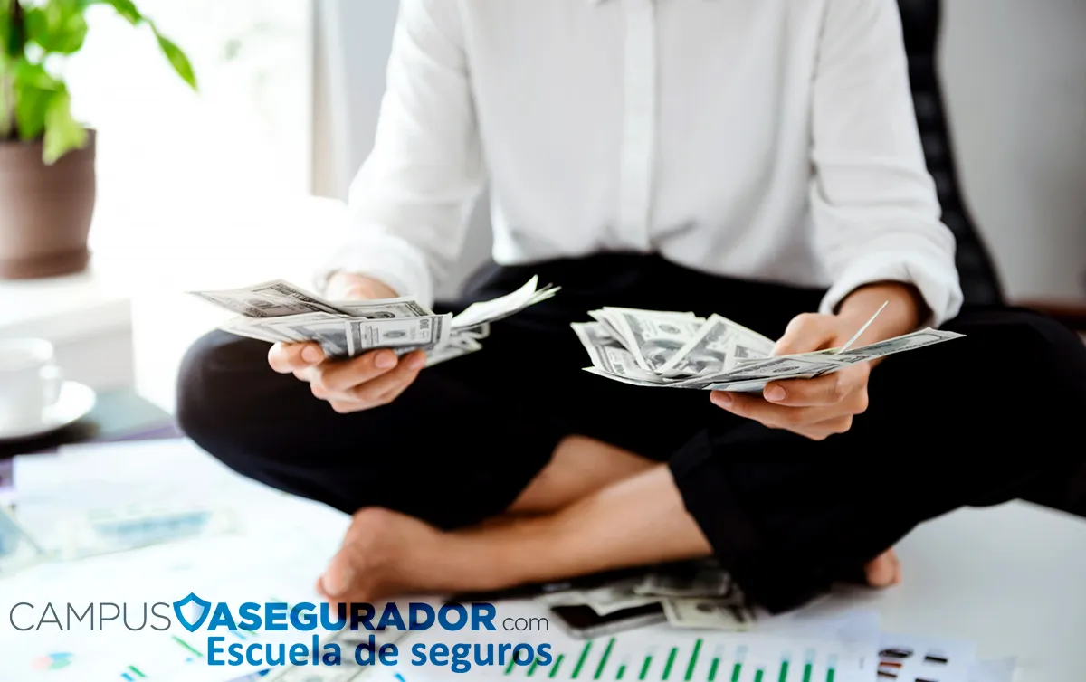 Persona sosteniendo billetes de cien dólares frente a gráficos de datos y marca Campus Asegurador Escuela de Seguros.