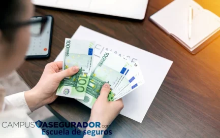 Persona contando billetes de cien euros sobre escritorio con laptop y logo de Campus Asegurador Escuela de Seguros.