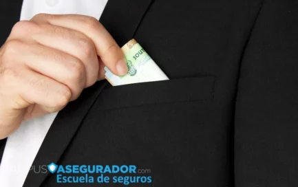 Mano de hombre en traje oscuro introduciendo billetes de rands sudafricanos en el bolsillo superior de la chaqueta.