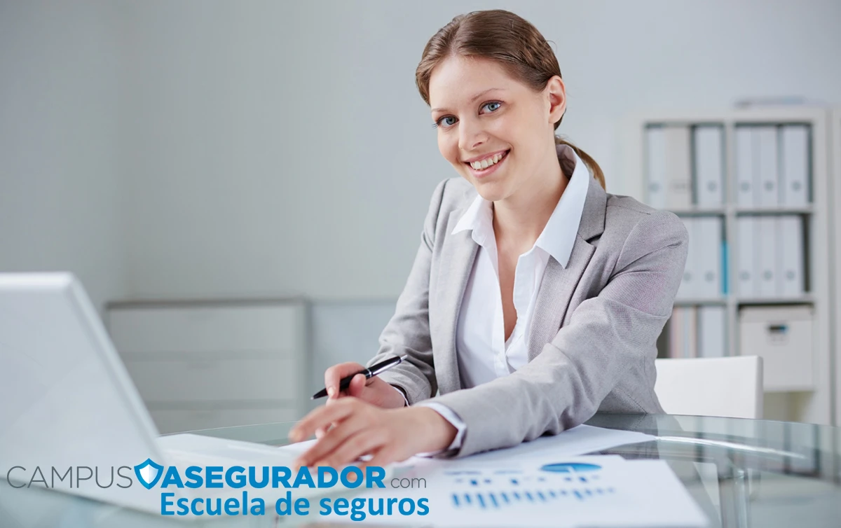 Mujer profesional analizando informes de datos en escritorio de Campus Asegurador, Escuela de Seguros.
