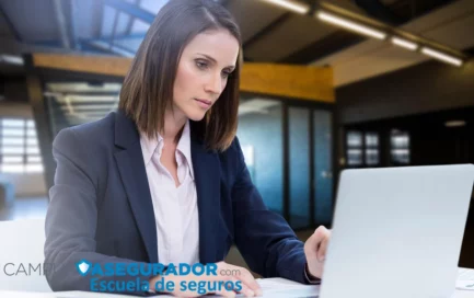 Mujer profesional trabajando en computadora portátil con marca corporativa Campus Asegurador Escuela de Seguros.