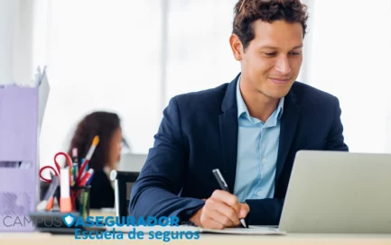 Profesional administrativo estudiando curso técnico de seguros con portátil y libreta en Campus Asegurador.