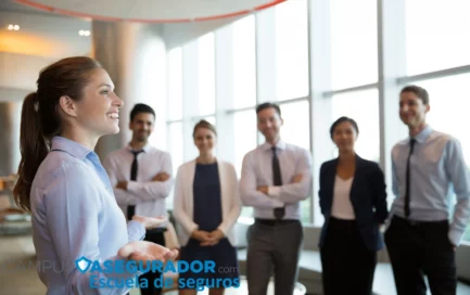 Mujer ponente en formación técnica de seguros con equipo corporativo en oficina luminosa bajo logo Campus Asegurador.