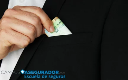 Persona con traje negro guardando billetes de rand sudafricano en el bolsillo superior de la chaqueta.