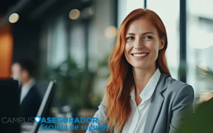 Mujer profesional pelirroja sonriendo en oficina corporativa para formación de Campus Asegurador.