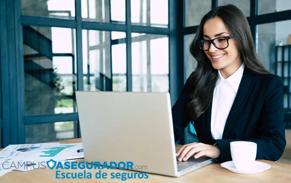 Mujer con gafas y traje usando portátil junto a gráficas. Logotipo de Campus Asegurador en la esquina inferior.