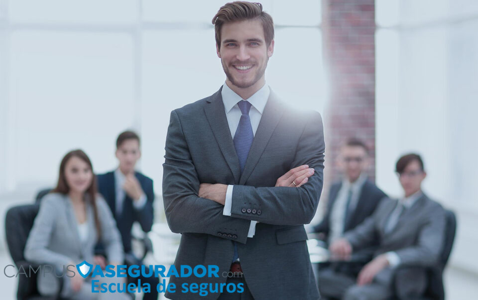 Director de seguros sonriente con traje liderando equipo. Branding Campus Asegurador Escuela de Seguros.