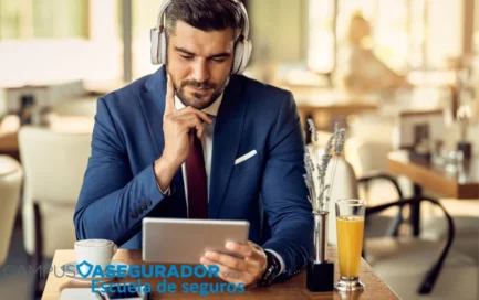 Profesional con auriculares y tablet estudiando curso de seguros online de Campus Asegurador en una cafetería.
