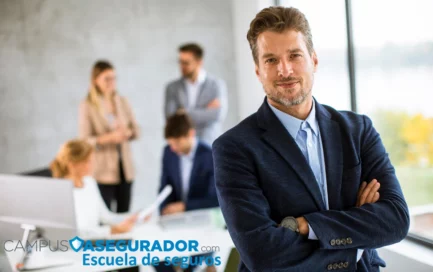 Profesional sonriente con brazos cruzados en oficina de Campus Asegurador, escuela de formación en seguros.