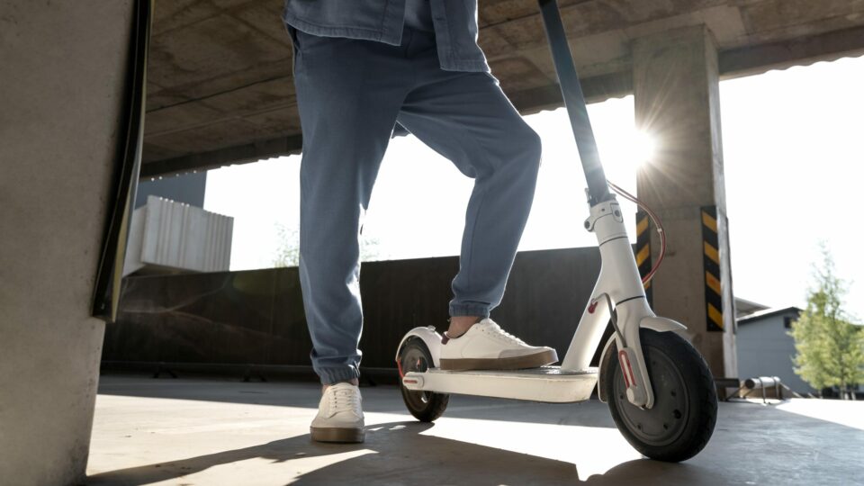 hombre con su scooter en un estacionamiento en el interior