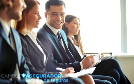 Profesionales en traje asisten a clase de seguros en Campus Asegurador, tomando notas en ambiente corporativo iluminado.