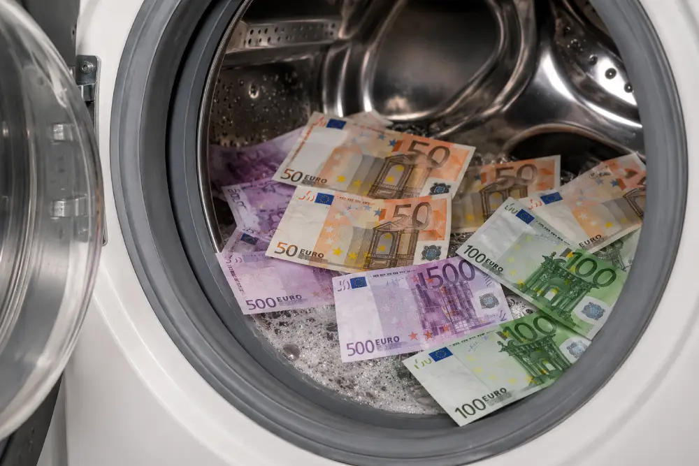 Prevención de Blanqueo de Capitales en Seguros Billetes de 50, 100 y 500 euros en tambor de lavadora representando blanqueo de capitales para sector seguros.